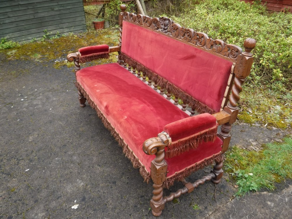 A late nineteenth-century carved oak hall bench featuring red velvet upholstery with fringe trim and barley twist legs. View IX