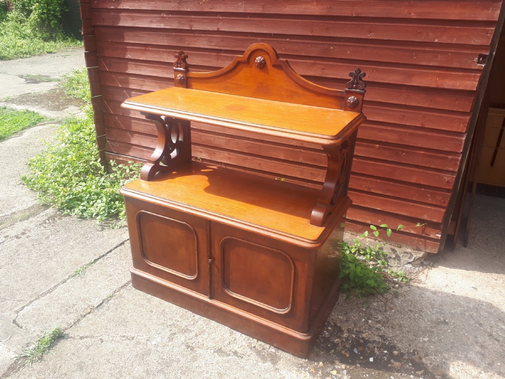 A 19th-century Victorian mahogany side cabinet featuring a two-door base cupboard, open display tier with scroll supports, and a carved gallery back. View II