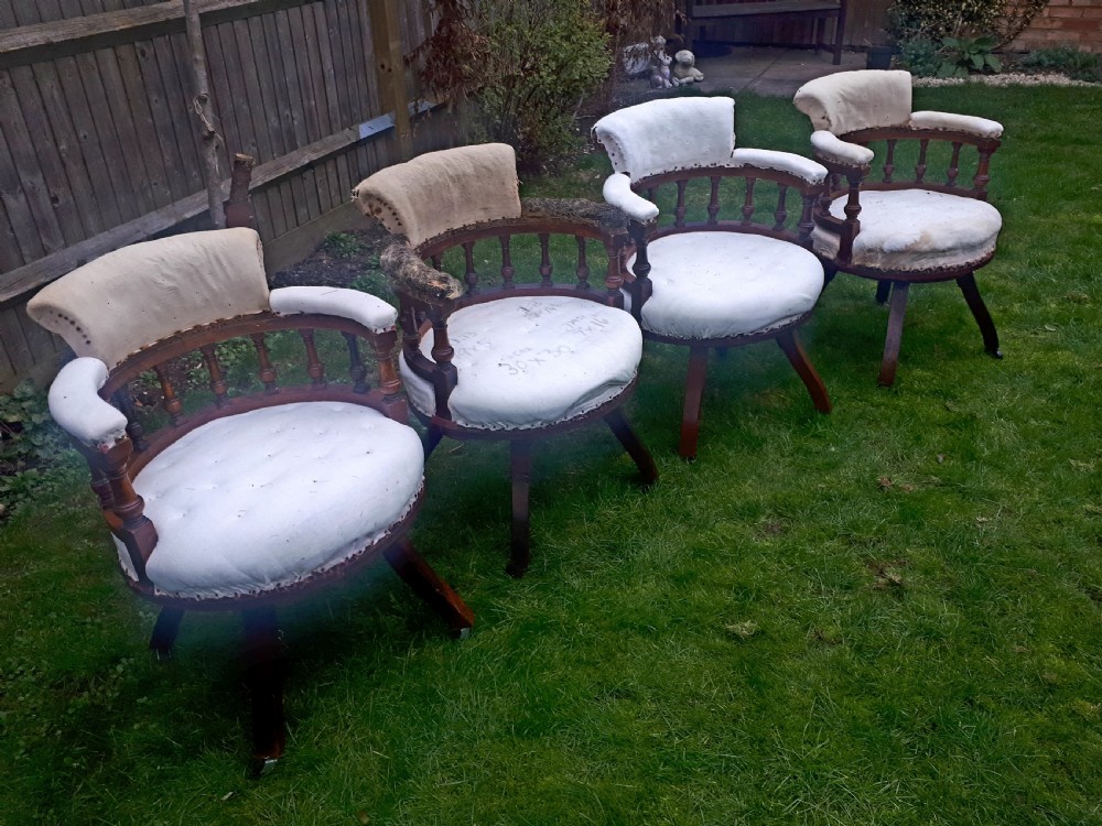 A set of four late nineteenth-century oak revolving desk armchairs featuring turned spindles, splayed legs on castors, and calico upholstery. View II