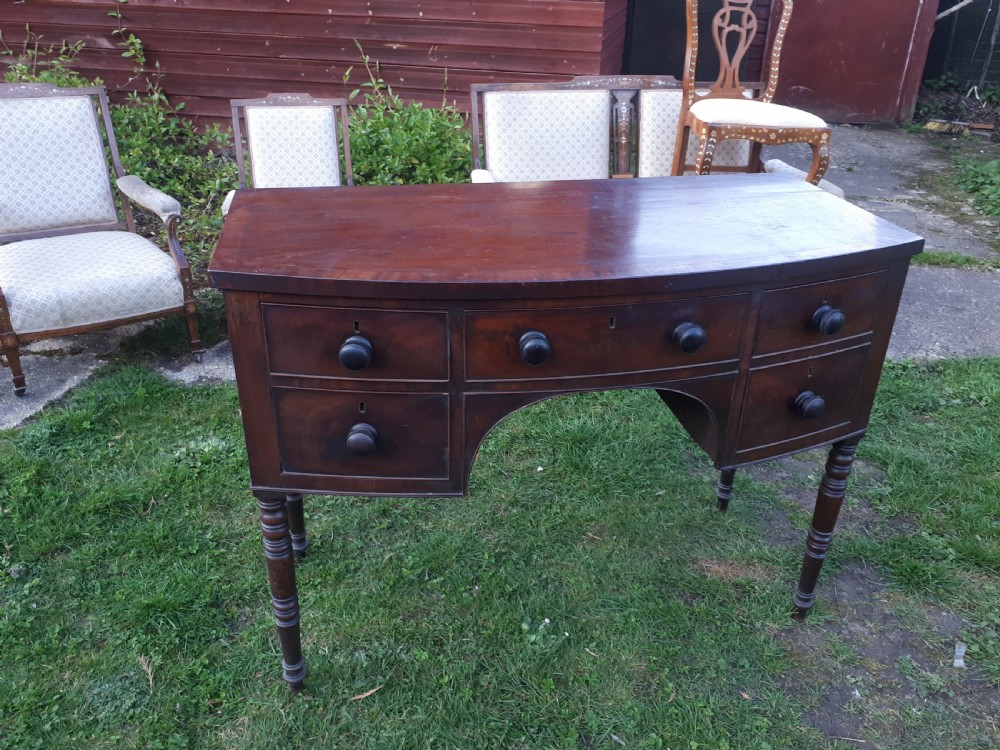 A nineteenth-century Regency mahogany bow-fronted sideboard featuring five drawers with turned wooden knobs and four turned legs. View II