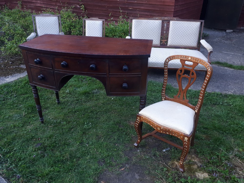A nineteenth-century Regency mahogany bow-fronted sideboard featuring five drawers with turned wooden knobs and four turned legs. View VI