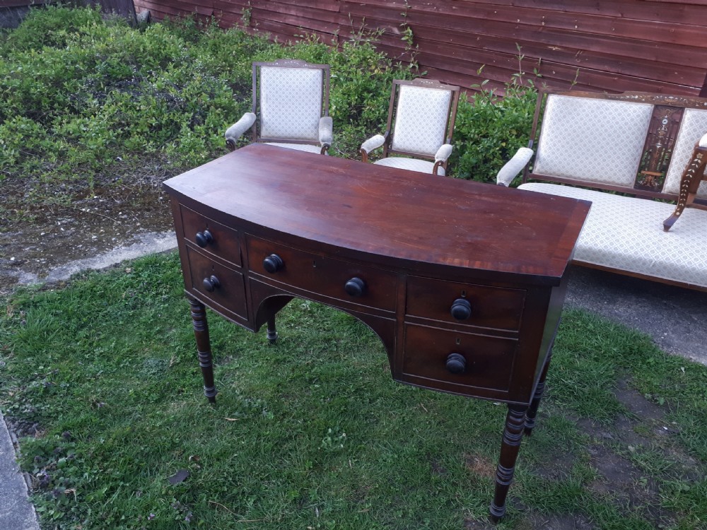 A nineteenth-century Regency mahogany bow-fronted sideboard featuring five drawers with turned wooden knobs and four turned legs. View VIII