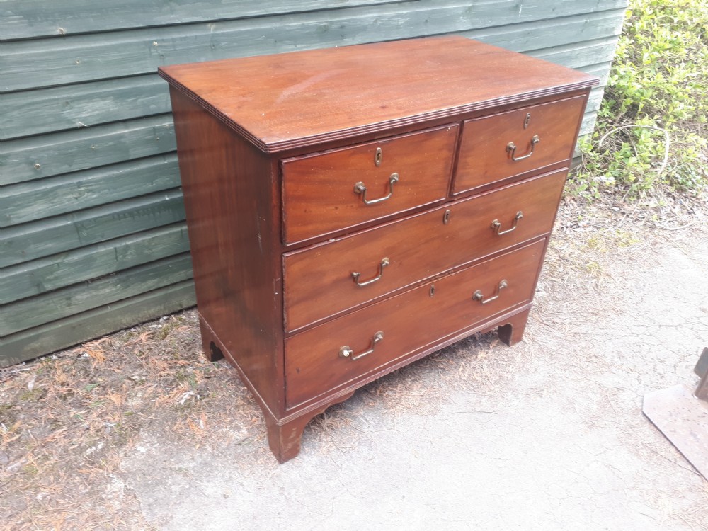 A Regency mahogany chest of drawers featuring two short drawers over two full-width long drawers, brass drop handles, and bracket feet.
