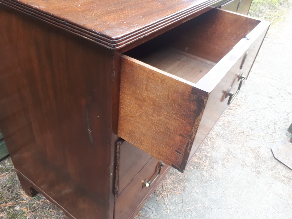 A Regency mahogany chest of drawers featuring two short drawers over two full-width long drawers, brass drop handles, and bracket feet. View II