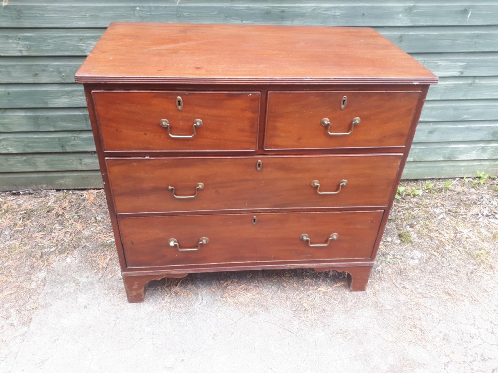A Regency mahogany chest of drawers featuring two short drawers over two full-width long drawers, brass drop handles, and bracket feet. View III