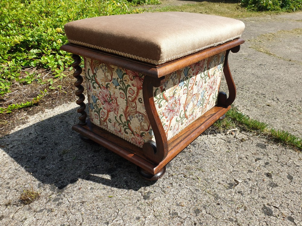 An early Victorian rosewood box seat stool with a brown padded cushion seat, floral upholstered fabric side panels, and shaped wooden supports. View III