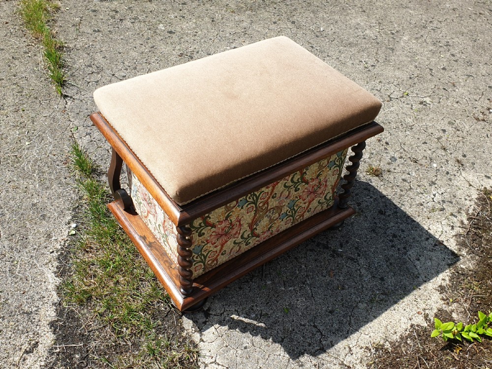 An early Victorian rosewood box seat stool with a brown padded cushion seat, floral upholstered fabric side panels, and shaped wooden supports. View V