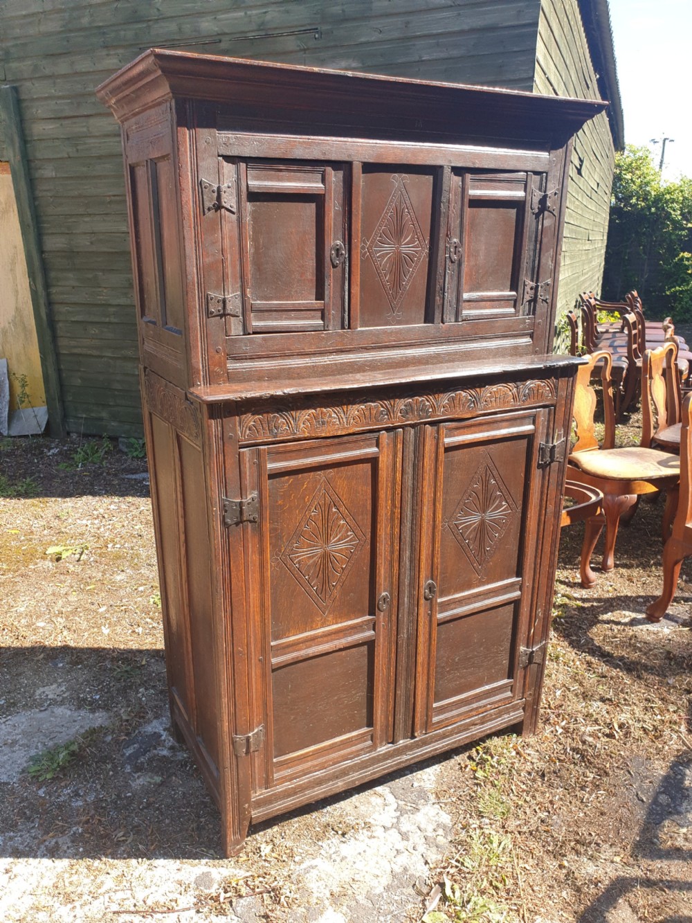 Neat and useful antique carved oak hall cupboard .