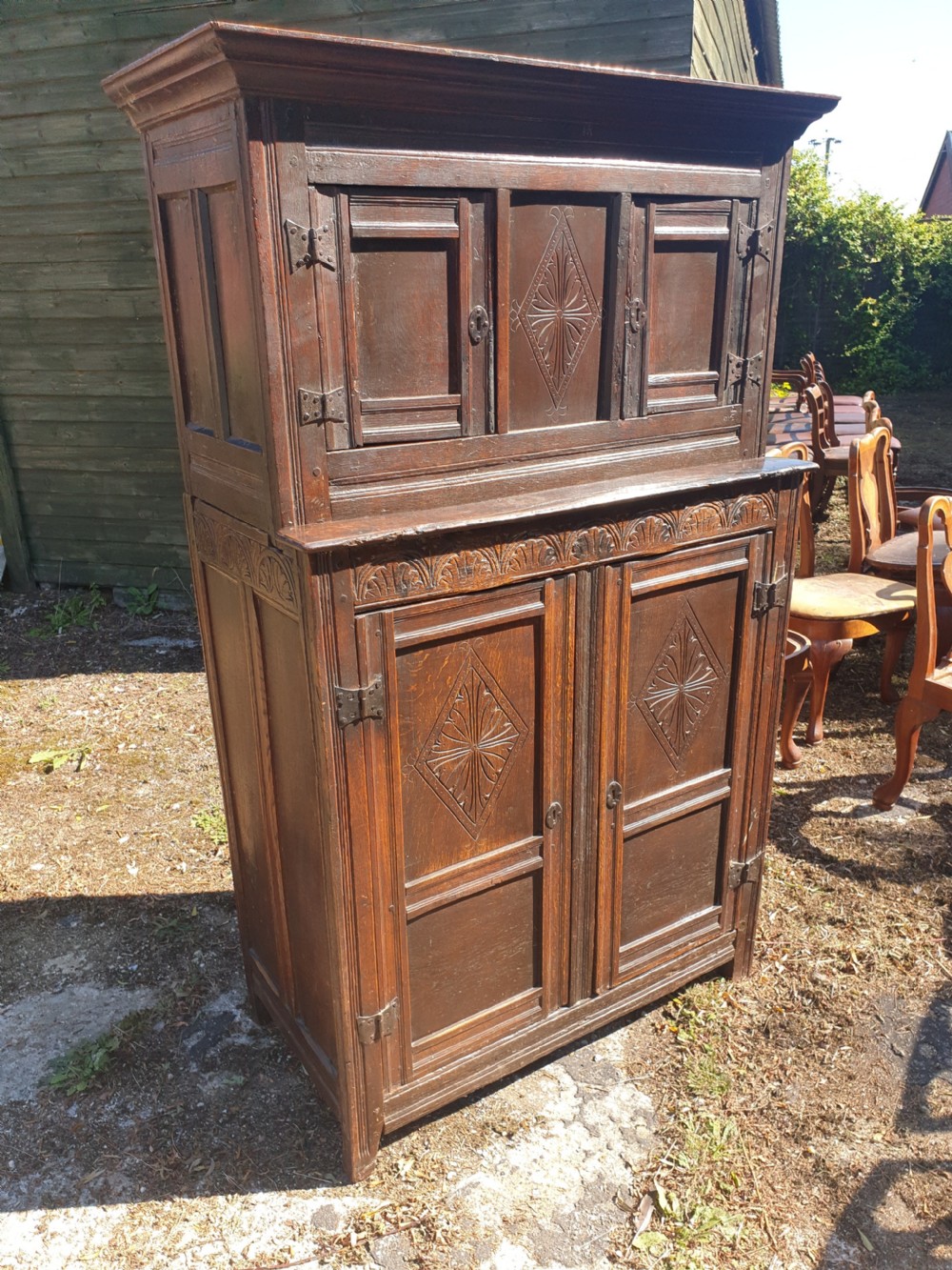Neat and useful antique carved oak hall cupboard . View II