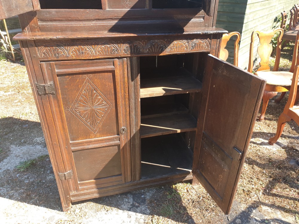 Neat and useful antique carved oak hall cupboard . View V
