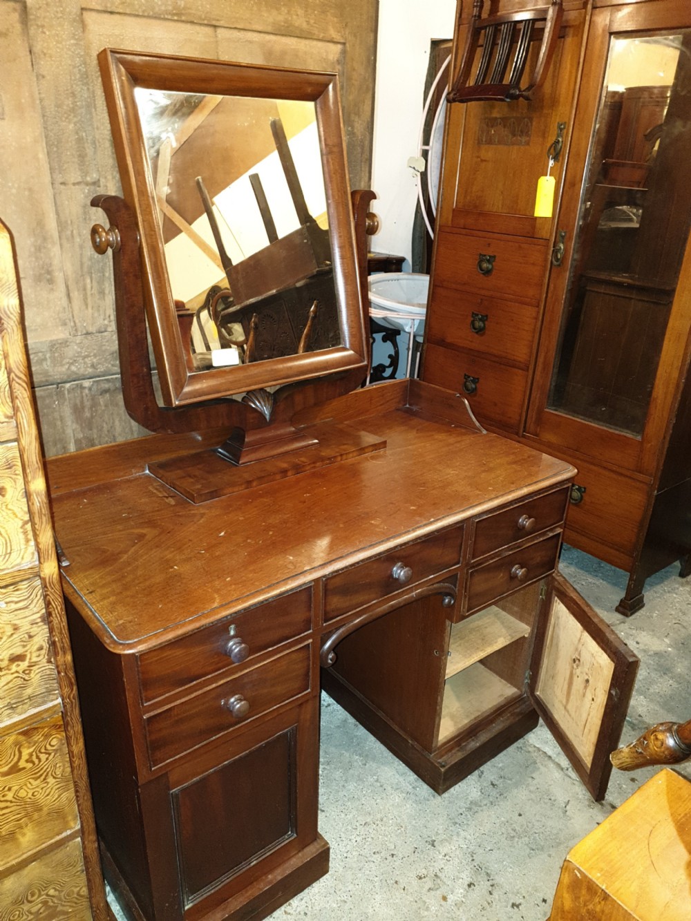 Mid-19th-century mahogany kneehole dressing table featuring an integrated rectangular swivel mirror, turned wooden knobs, and twin pedestal drawer bases. View II