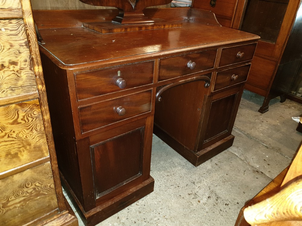 Mid-19th-century mahogany kneehole dressing table featuring an integrated rectangular swivel mirror, turned wooden knobs, and twin pedestal drawer bases. View V