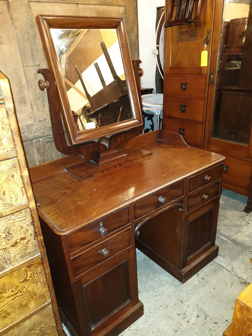Mid-19th-century mahogany kneehole dressing table featuring an integrated rectangular swivel mirror, turned wooden knobs, and twin pedestal drawer bases. View VI