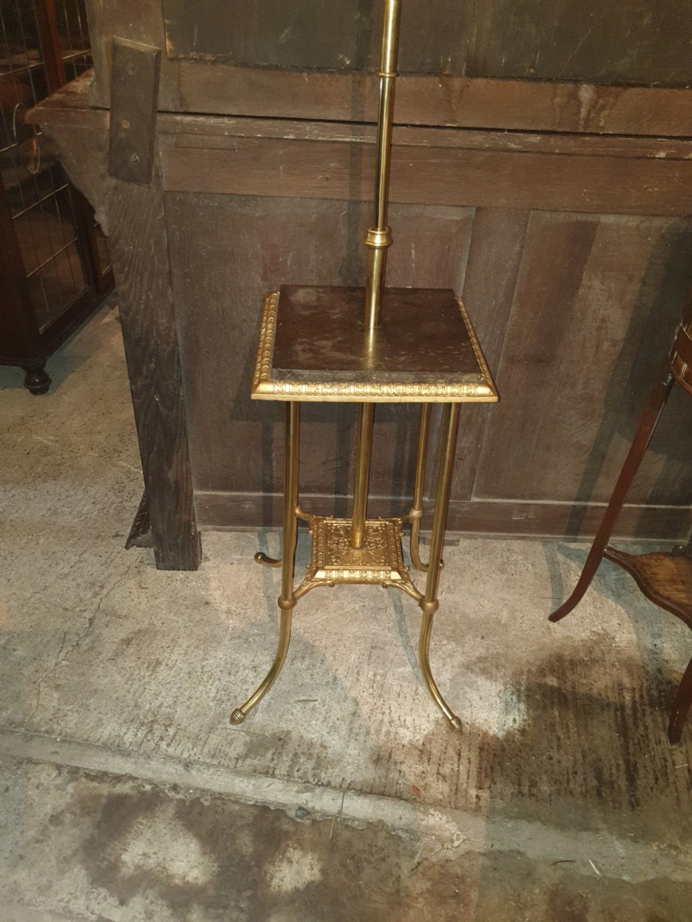 A Victorian brass floor lamp featuring an integrated square tier, splayed legs, and a white frilled milk glass shade. View VIII
