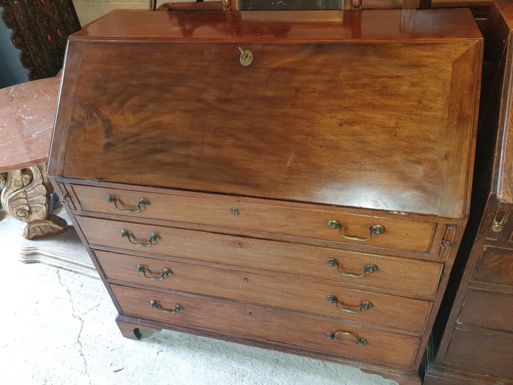 An early 19th century mahogany slant-front bureau featuring a fitted interior with small drawers and pigeonholes above two wide lower drawers with brass handles. View III