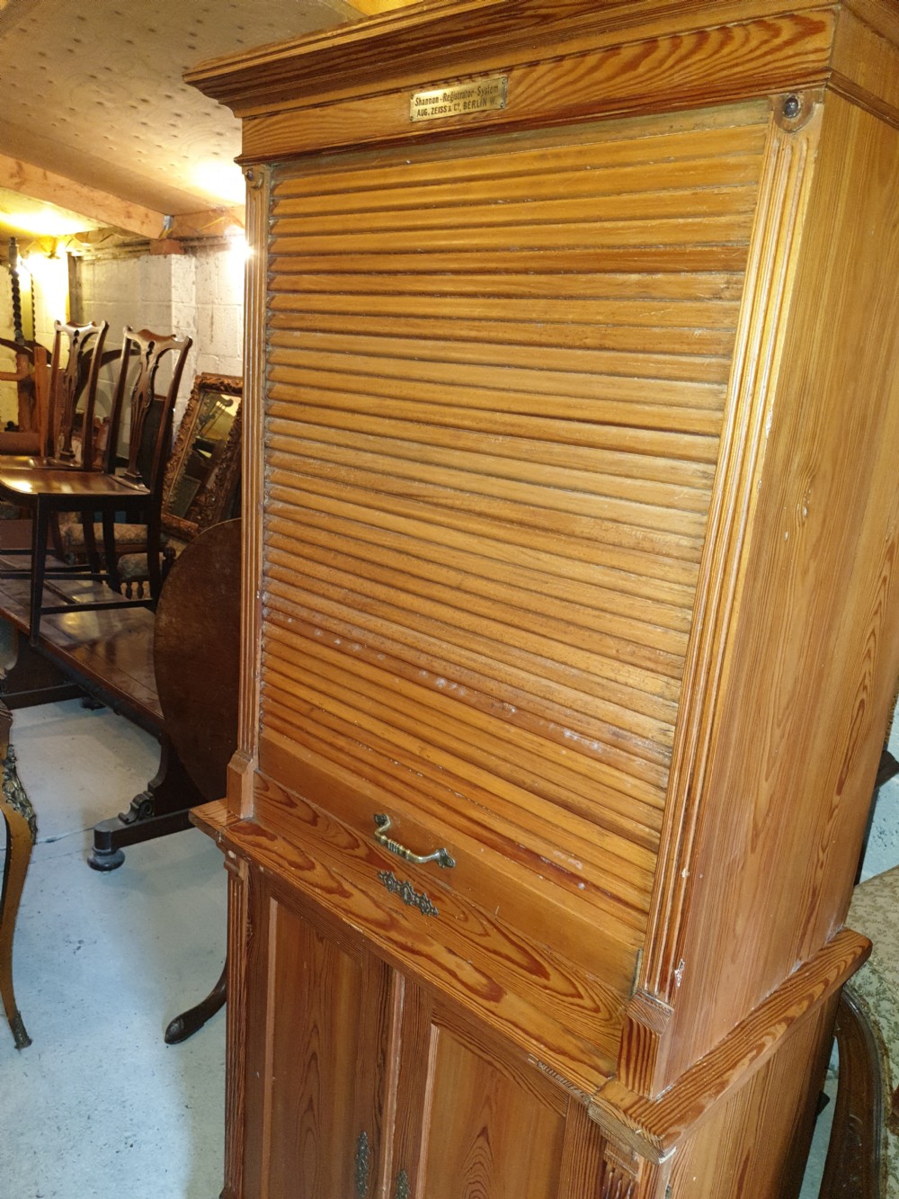 A tall Edwardian pine office cabinet featuring a slatted tambour roll shutter upper section above a two-door panelled lower cupboard. View VII