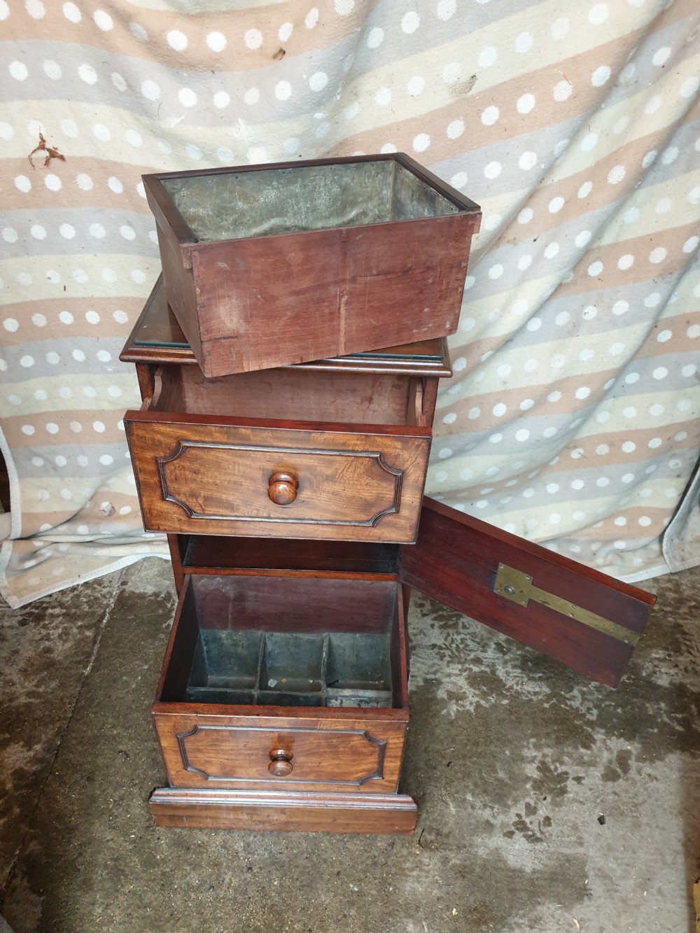 An early nineteenth-century mahogany cabinet-style wine cooler featuring a removable metal-lined top box, drawers with internal bottle dividers, moulded panels, turned wooden knobs, and a hinged side door.