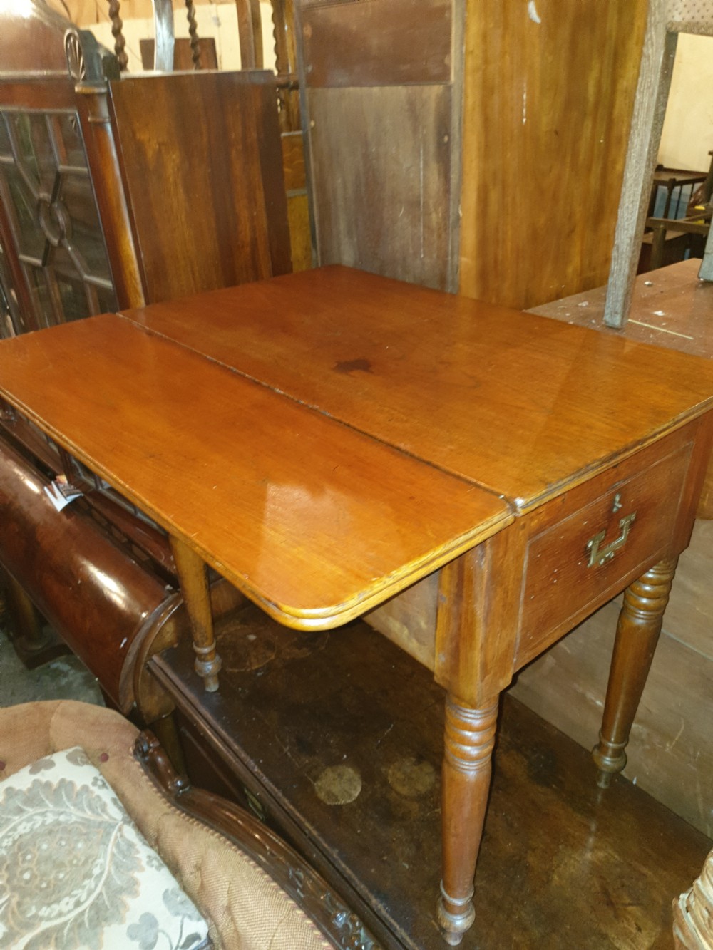 An antique teak ships washstand table featuring a hinged lid opening to reveal circular basin cutouts, resting on turned legs with brass side handles. View III