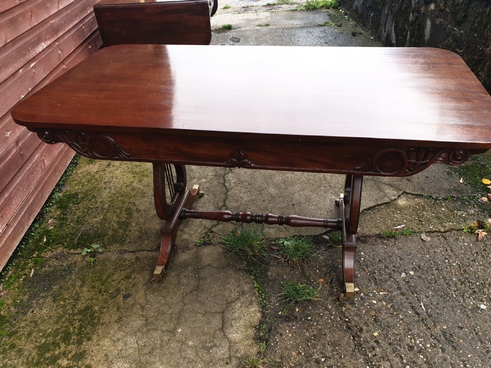 A 19th-century mahogany side table with an open single drawer, carved scroll frieze, lyre end supports, and brass castors. View III
