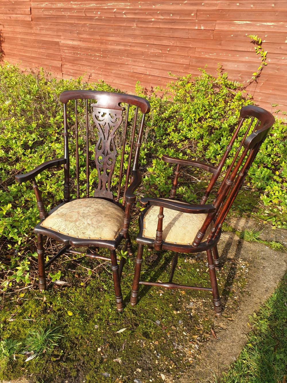 A pair of dark mahogany Edwardian hall armchairs featuring pierced carved back splats, turned spindle supports, curved armrests, and patterned upholstered seats with stud trim. View IV