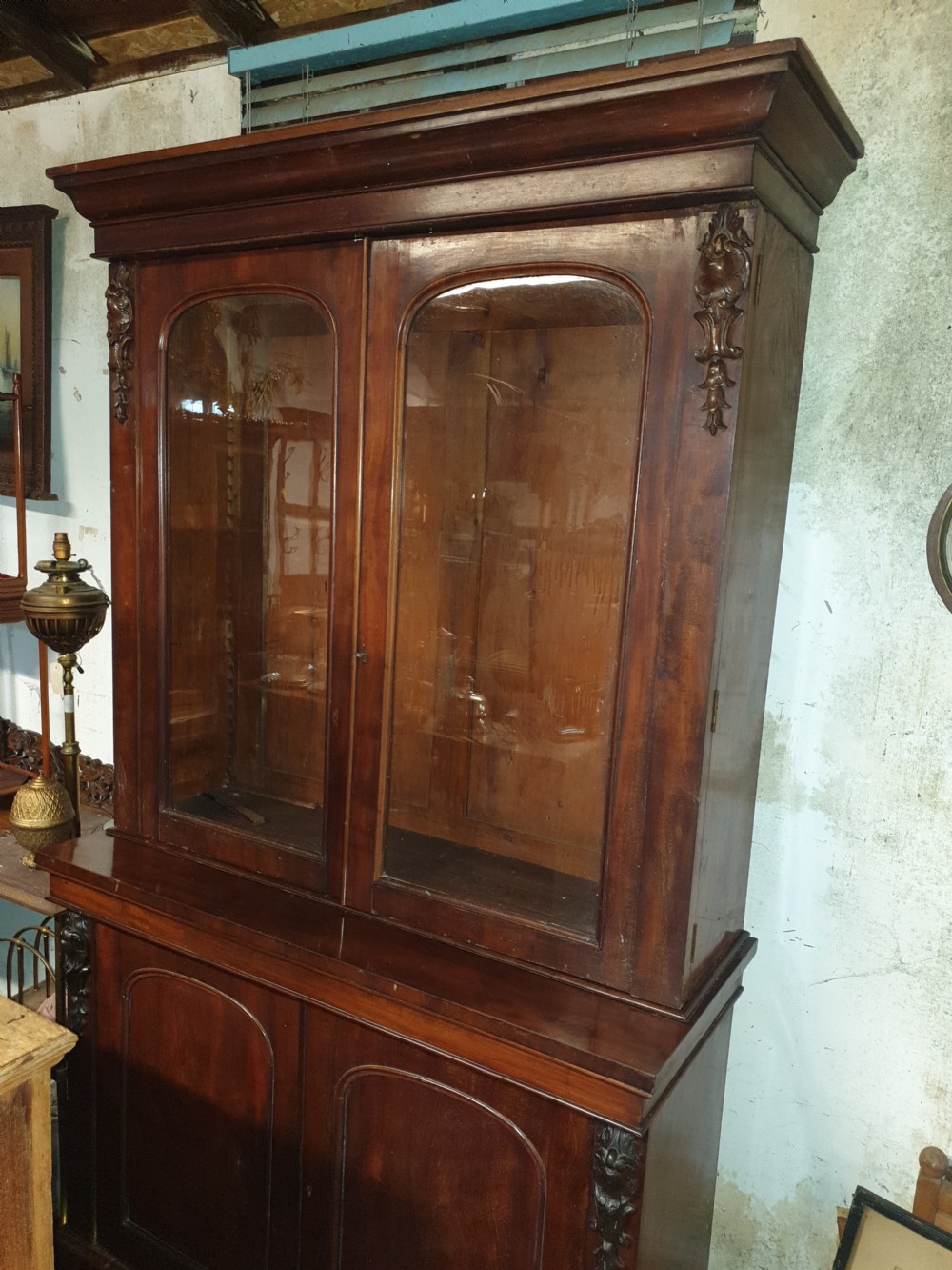 A mid-19th century Victorian mahogany two-part bookcase featuring a glazed upper cabinet with arched glass panes above a lower cupboard base. View II