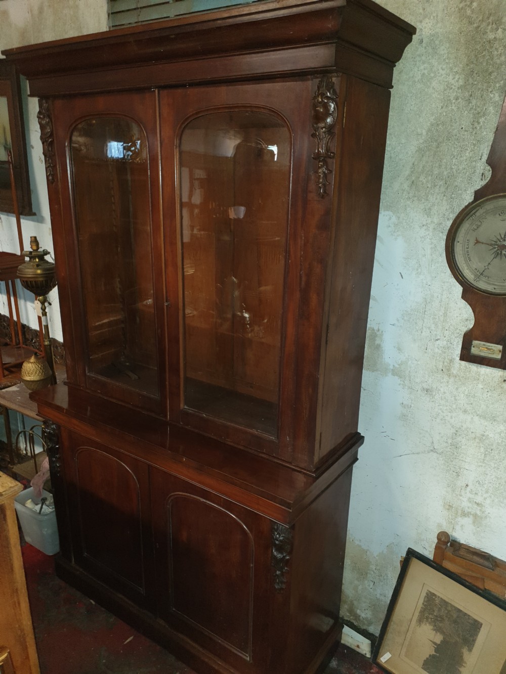 A mid-19th century Victorian mahogany two-part bookcase featuring a glazed upper cabinet with arched glass panes above a lower cupboard base. View VI