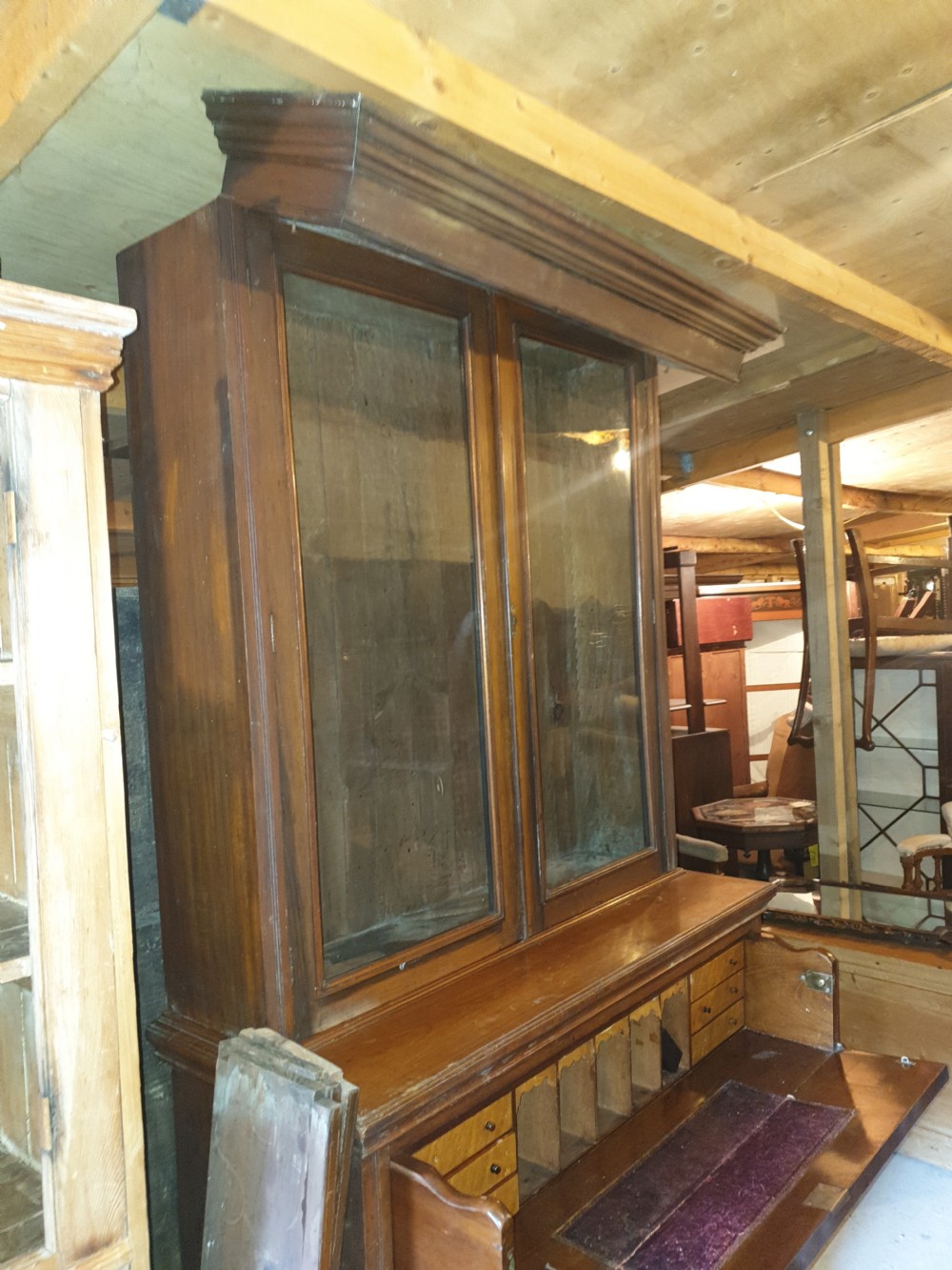 A late Victorian walnut secretaire bookcase featuring double glazed upper doors, a pull-out fitted writing drawer with interior compartments, and carved lower doors. View VI