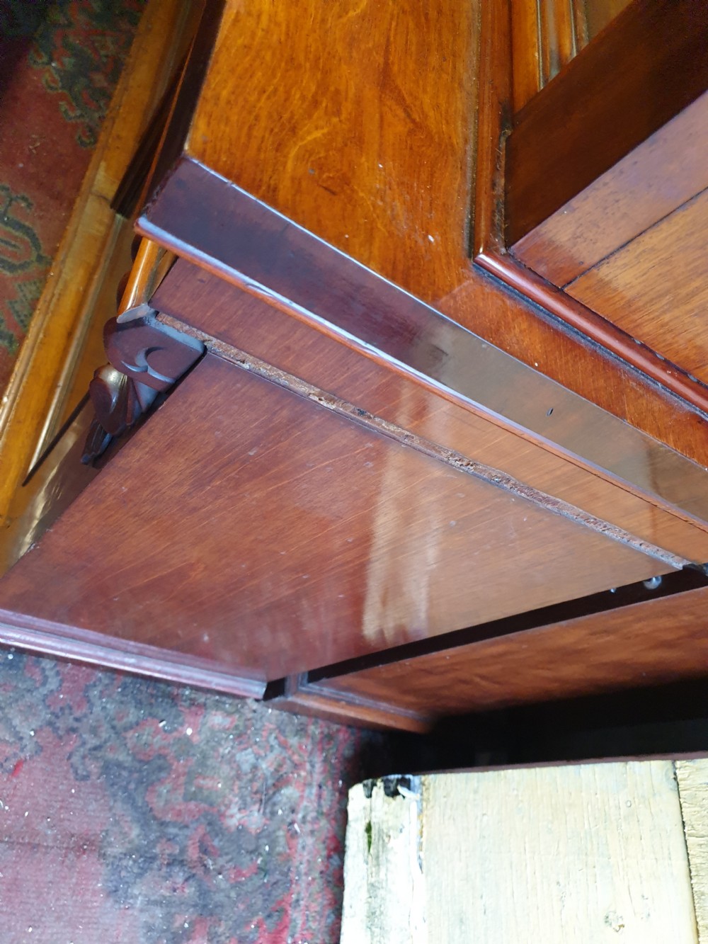 A Victorian mahogany library bookcase featuring upper double glazed doors, carved corner corbels, internal wooden shelving, and a lower two-door panelled cupboard base. View VIII