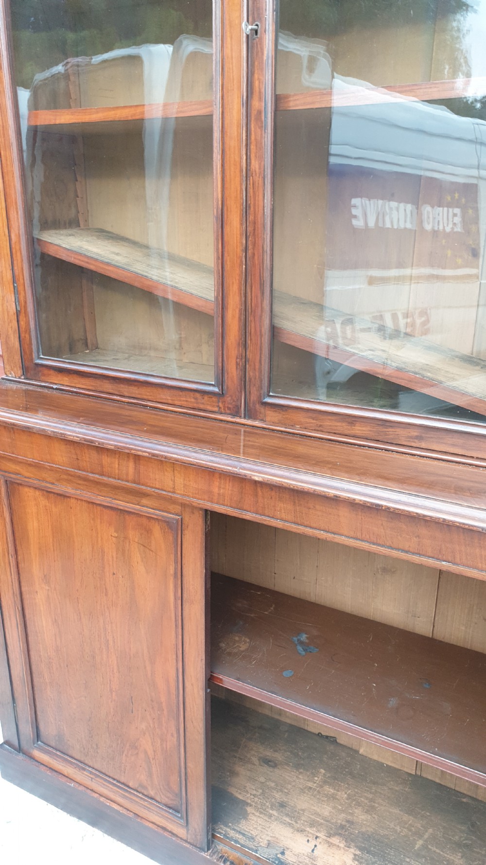 A tall Victorian two-part mahogany library bookcase featuring an upper glass-front cabinet over a solid two-door panelled cupboard base. View II
