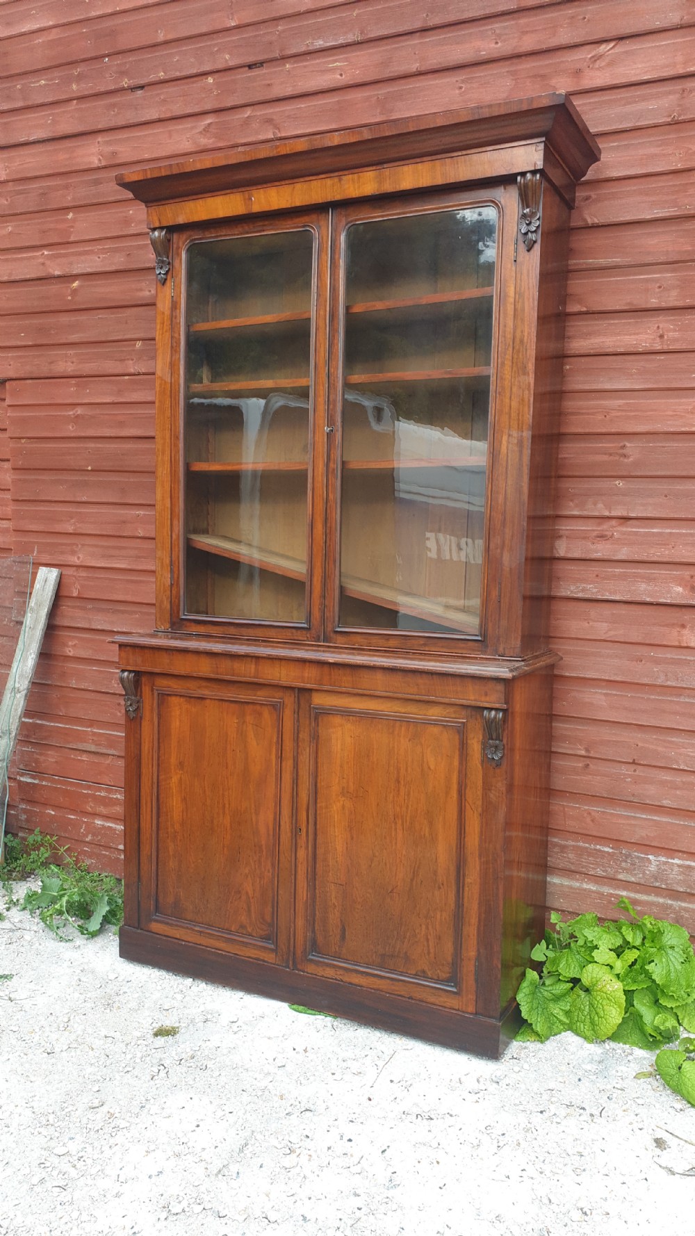 A tall Victorian two-part mahogany library bookcase featuring an upper glass-front cabinet over a solid two-door panelled cupboard base. View III