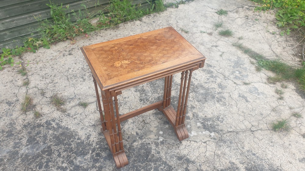 A set of three graduated wooden nesting tables featuring geometric parquetry tops inlaid with delicate floral and bird motifs. View II