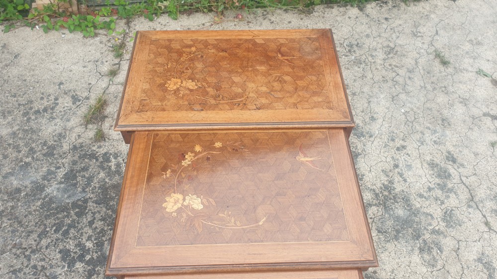 A set of three graduated wooden nesting tables featuring geometric parquetry tops inlaid with delicate floral and bird motifs. View IV