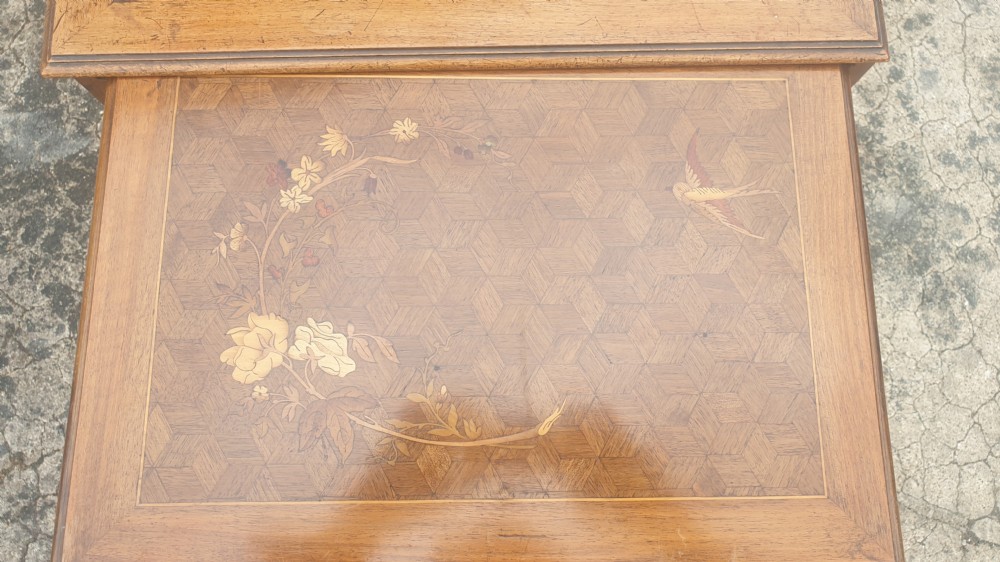 A set of three graduated wooden nesting tables featuring geometric parquetry tops inlaid with delicate floral and bird motifs. View VIII