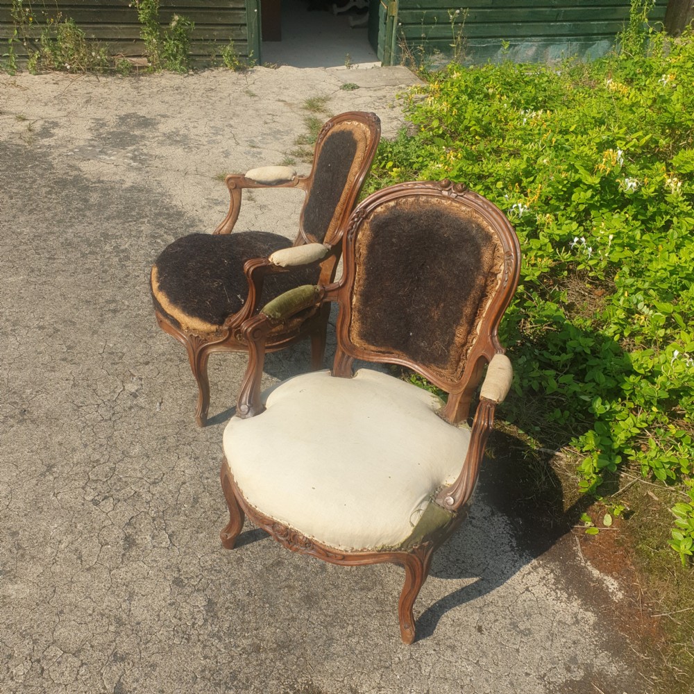 A pair of antique French Louis XV style carved wooden fauteuil armchairs stripped back to their padding and hessian foundation. View III