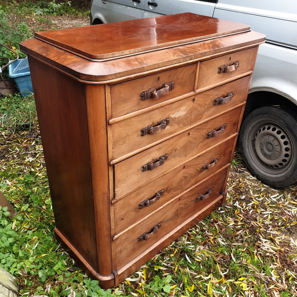 A large Victorian mahogany chest of drawers featuring two short over four long graduated drawers with carved wooden handles and a plinth base. View V