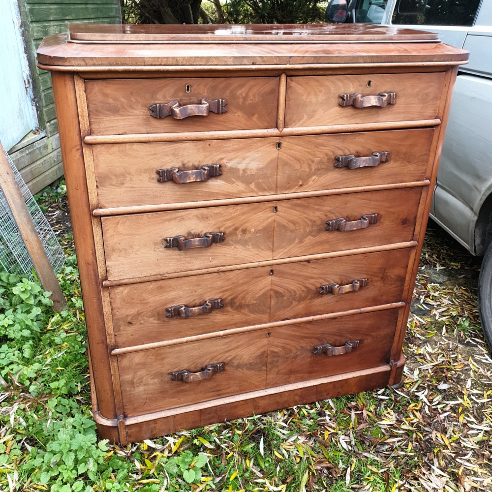 A large Victorian mahogany chest of drawers featuring two short over four long graduated drawers with carved wooden handles and a plinth base. View VI