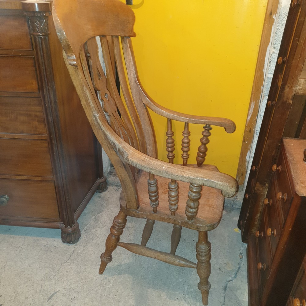 A Victorian farmhouse Windsor armchair made of timber featuring a shaped crest rail, pierced central splat, turned legs, and contoured seat. View II