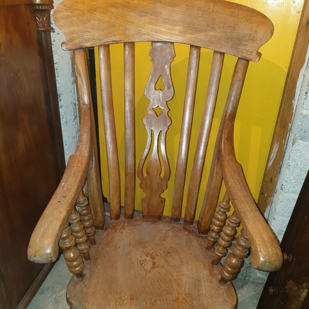 A Victorian farmhouse Windsor armchair made of timber featuring a shaped crest rail, pierced central splat, turned legs, and contoured seat. View III