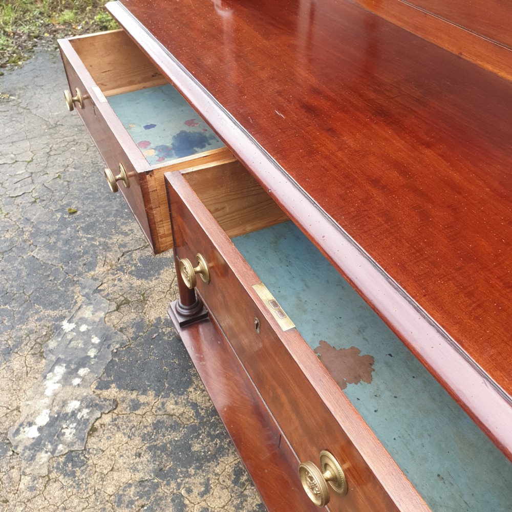 An antique Regency mahogany chiffonier cabinet featuring two raised shelves with turned supports, two drawers, and a double-door lower cabinet with brass lattice grilles and cream fabric backings. View III