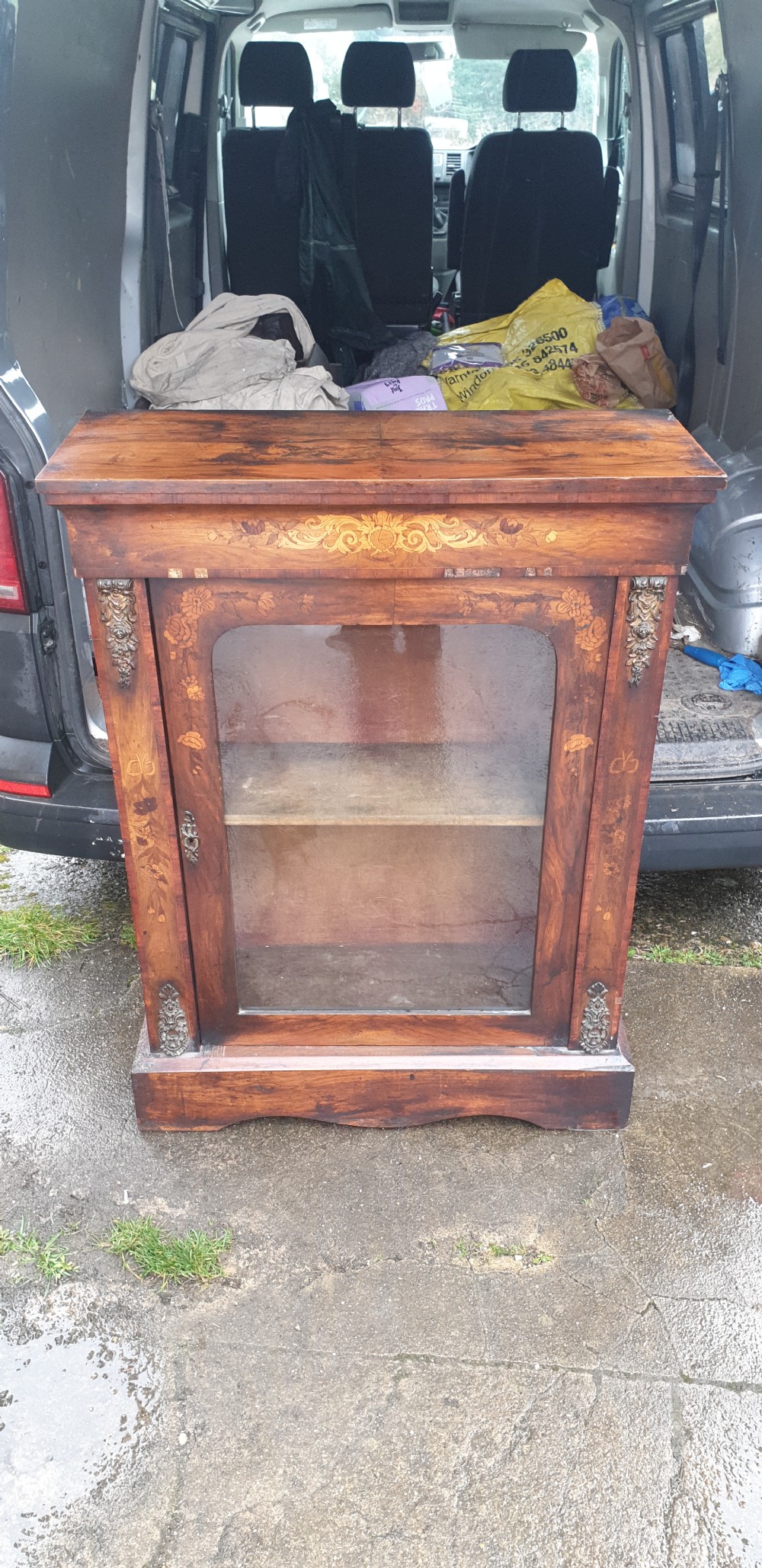 A Victorian walnut pier cabinet featuring floral marquetry inlay, a single glazed glass door, and gilt metal mounts on the side pilasters. View VI