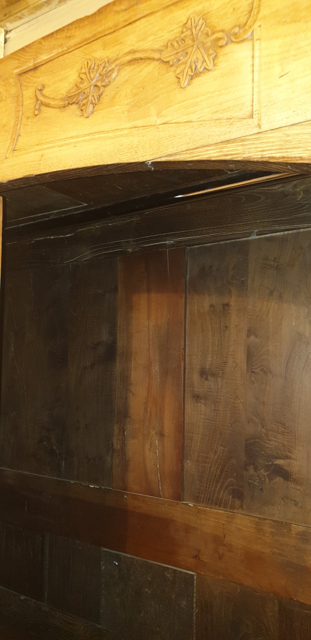 A tall French oak armoire featuring double panel doors decorated with carved floral motifs and long iron escutcheons. View IV