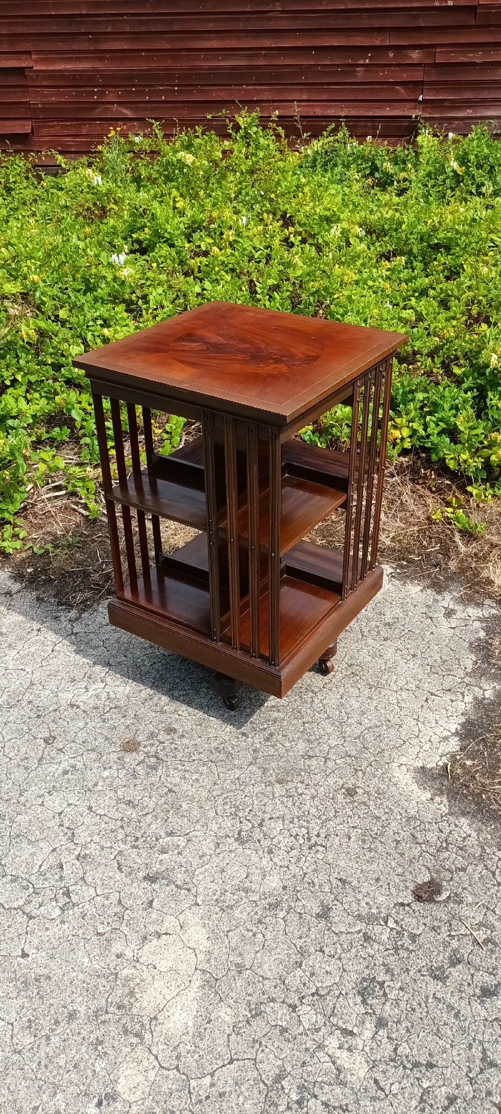 Edwardian inlaid revolving bookcase with metal base .