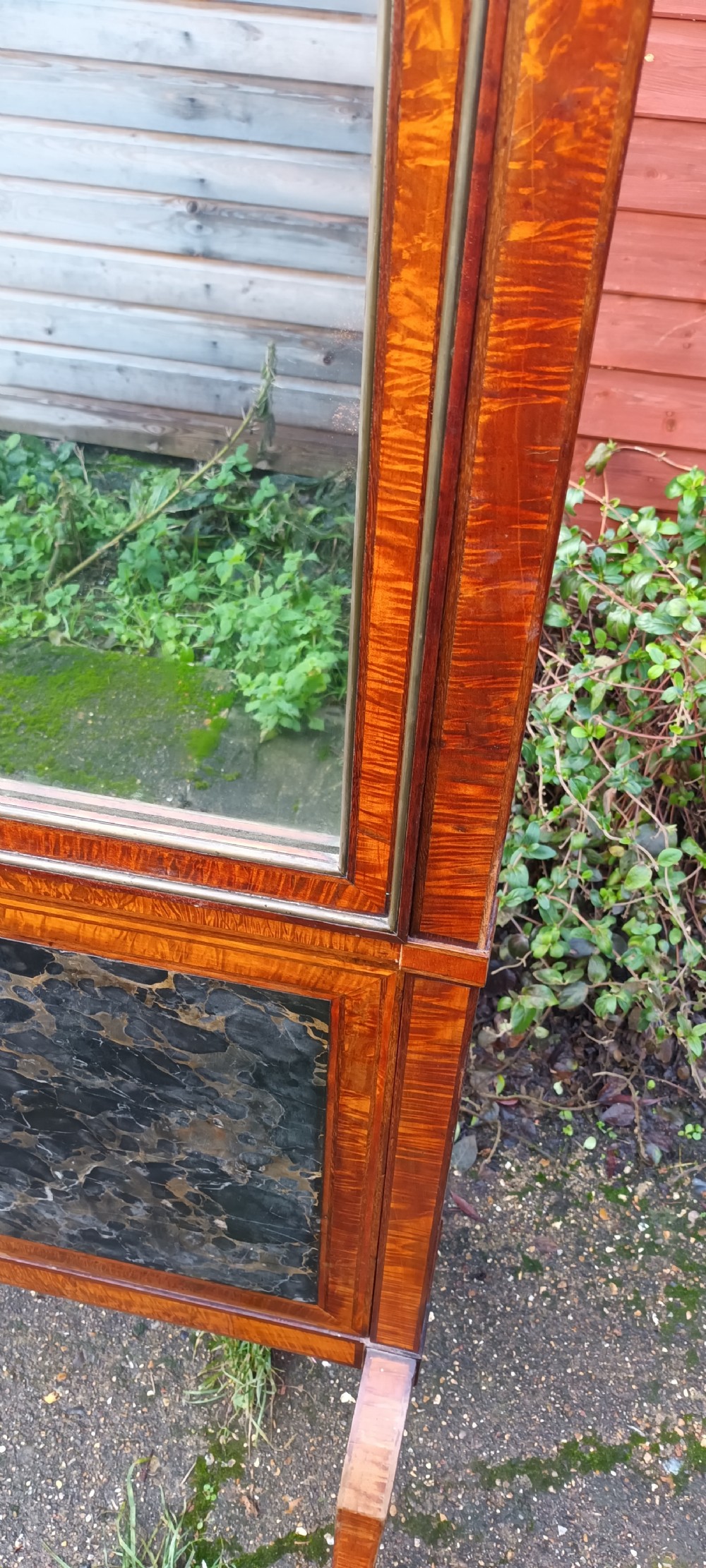An early nineteenth-century timber cheval mirror featuring a shaped crest, slender side posts with finials, and a fold-down lower marble panel resting on splayed feet. View II