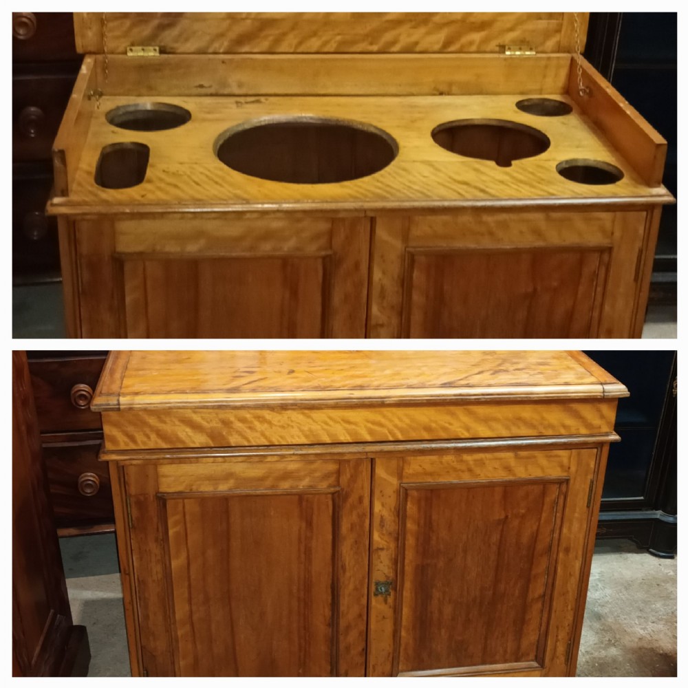A Victorian satin birch washstand cabinet with a hinged lid raised to show circular cutouts above two panelled doors. View II