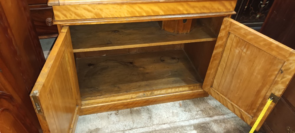 A Victorian satin birch washstand cabinet with a hinged lid raised to show circular cutouts above two panelled doors. View V