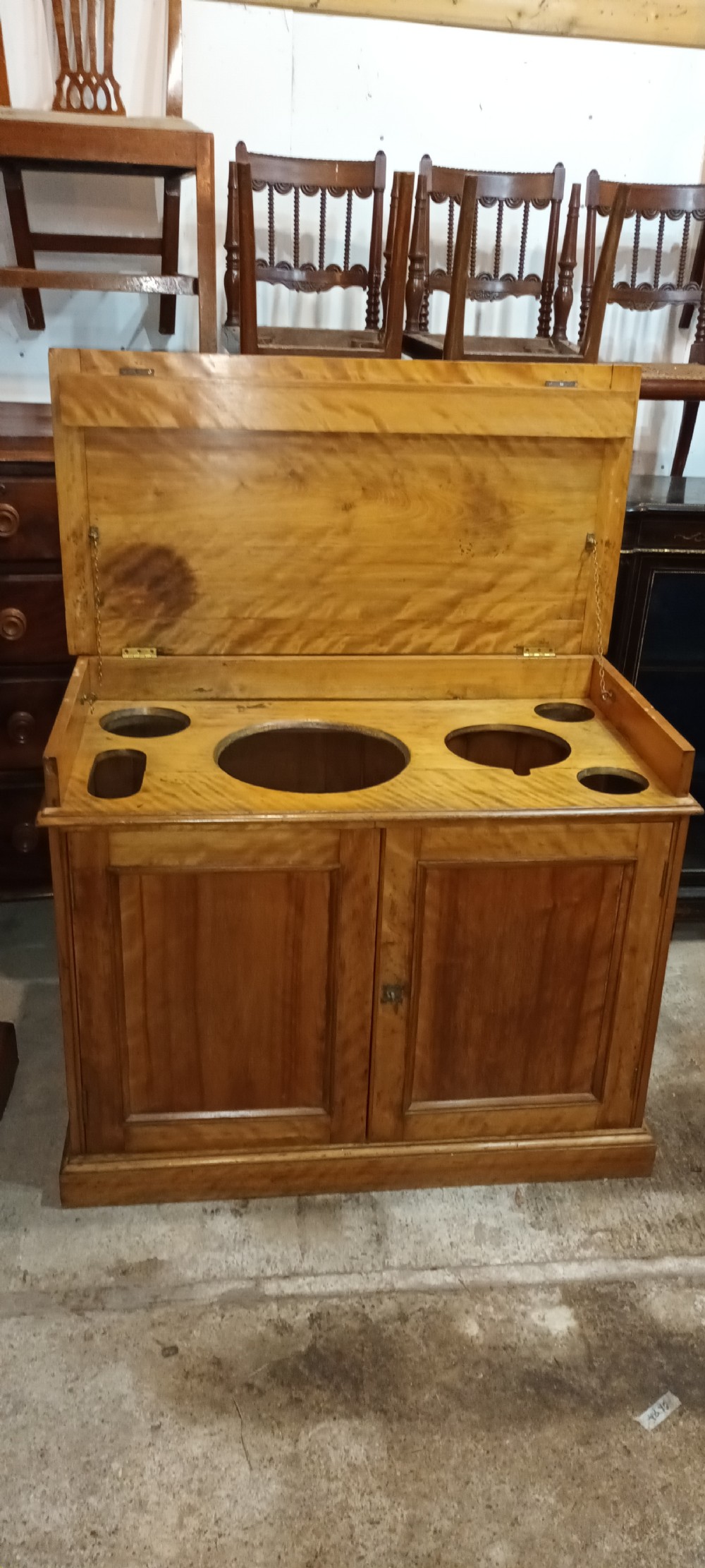 A Victorian satin birch washstand cabinet with a hinged lid raised to show circular cutouts above two panelled doors. View XIII