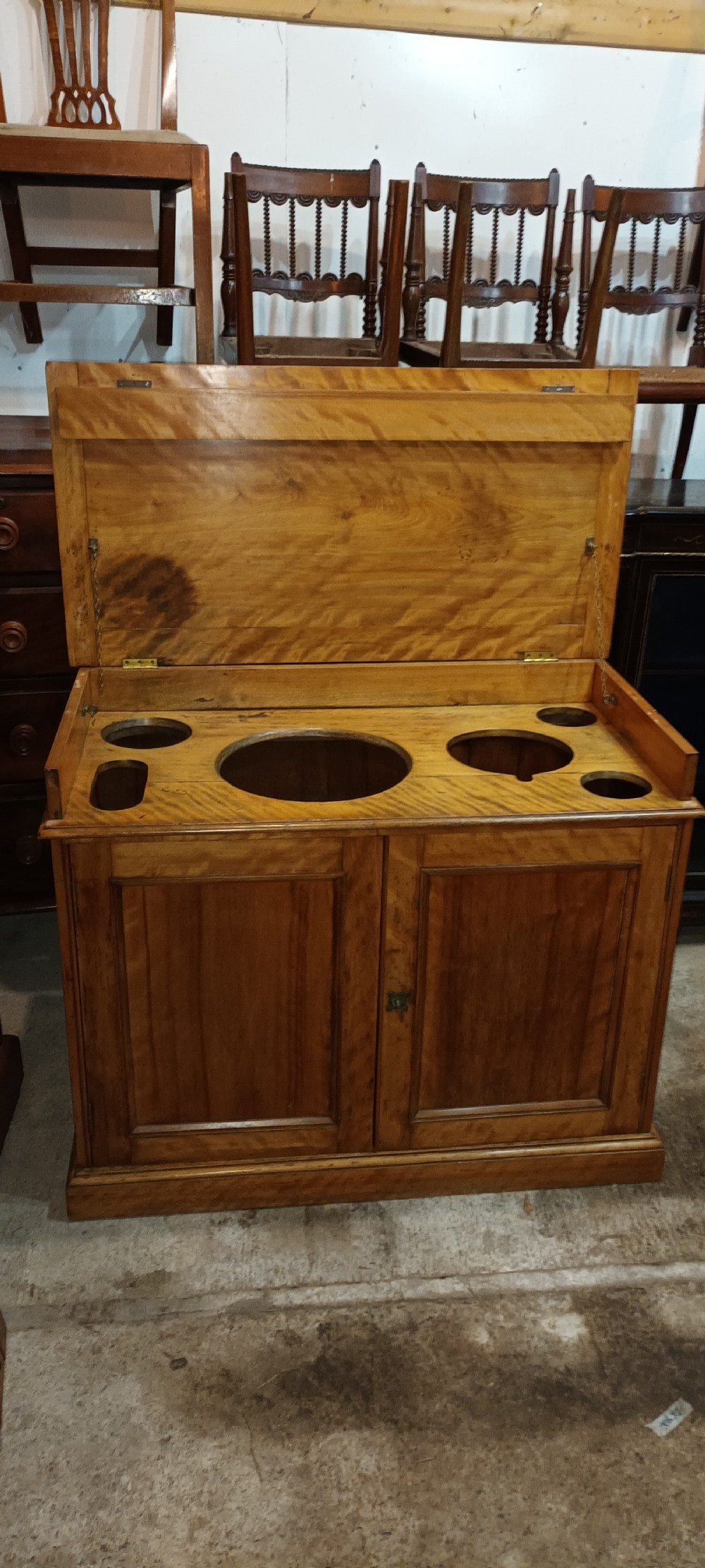 A Victorian satin birch washstand cabinet with a hinged lid raised to show circular cutouts above two panelled doors. View XIV