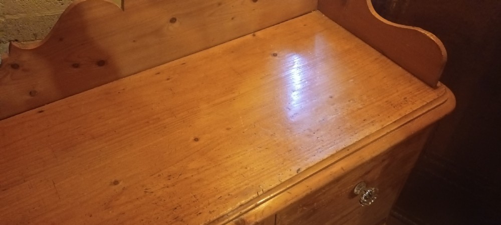 A Victorian pine chest of drawers featuring a scalloped gallery top, two short drawers over two long drawers, and clear glass knobs. View VIII