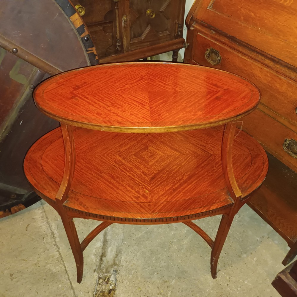 An Edwardian oval two-tier satinwood etagere side table with diamond-matched wood veneer and swept legs. View IV