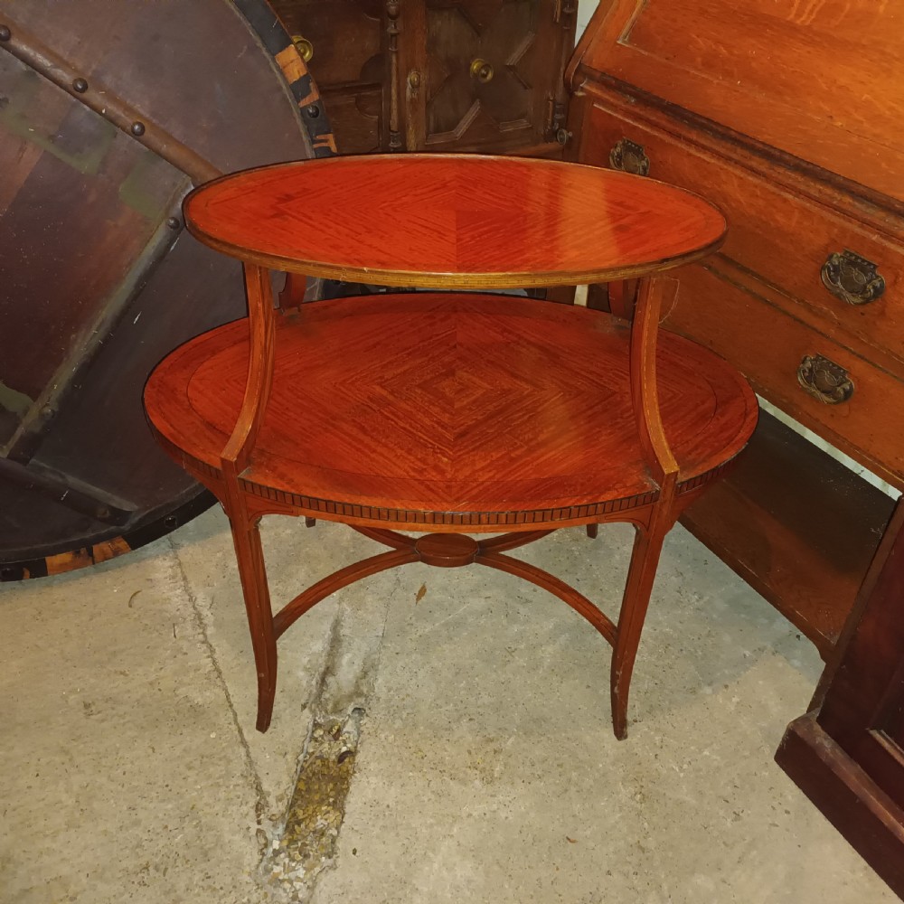An Edwardian oval two-tier satinwood etagere side table with diamond-matched wood veneer and swept legs. View V
